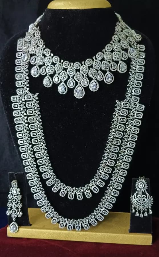 American diamond bridal jewellery set on a display stand — short necklace, long haram and jhumka, with white stones