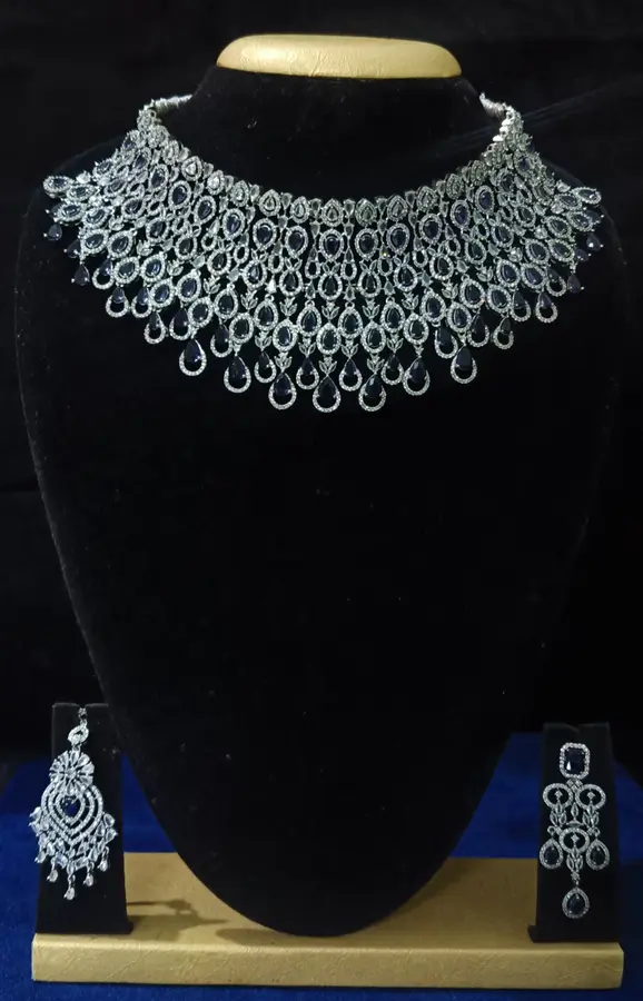 Stone-set bridal choker necklace with matching earrings on a display stand