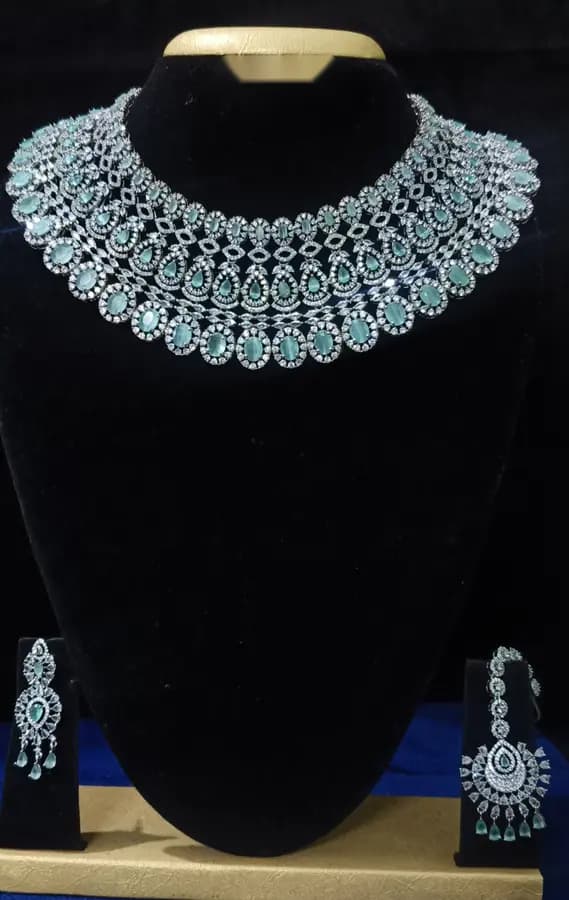Stone-set bridal choker necklace with matching earrings on a display stand