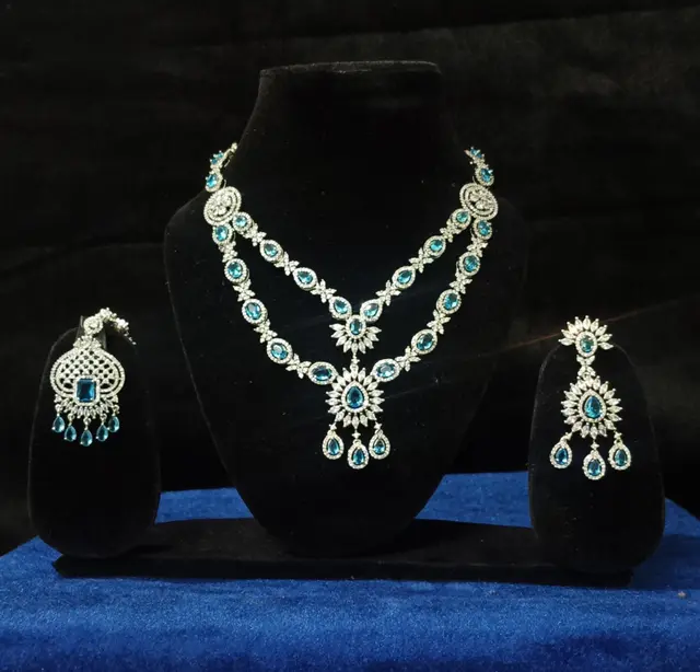 Stone-set bridal choker necklace with matching earrings on a display stand