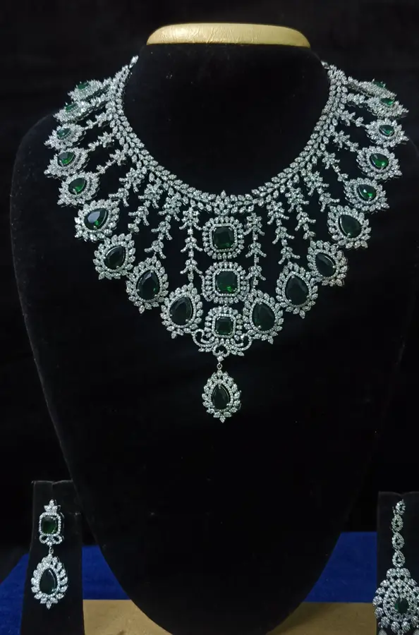 Stone-set bridal choker necklace with matching earrings on a display stand