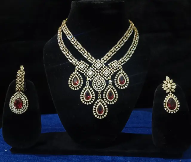 Stone-set bridal choker necklace with matching earrings on a display stand