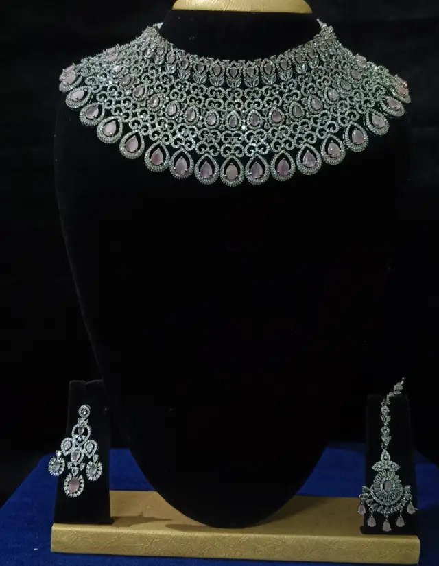 Stone-set bridal choker necklace with matching earrings on a display stand