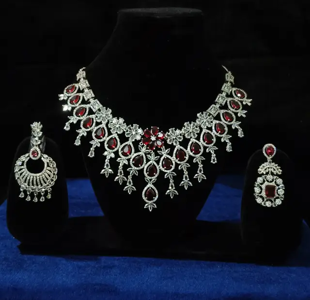 Stone-set bridal choker necklace with matching earrings on a display stand