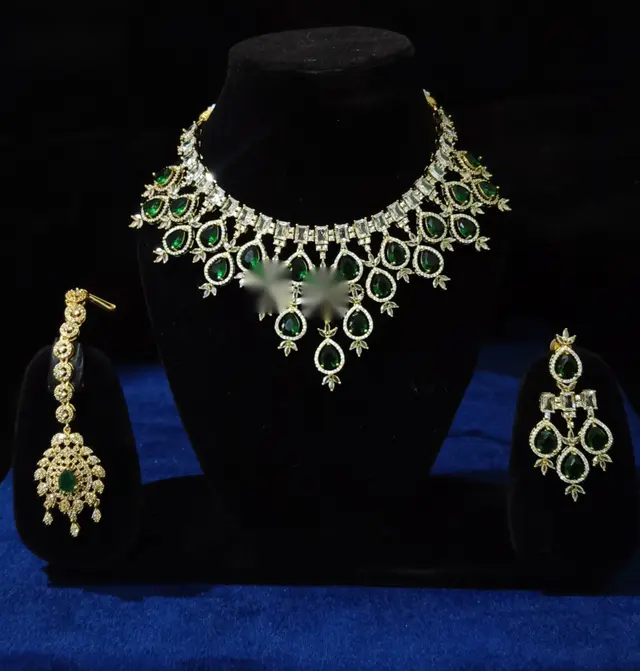 Stone-set bridal choker necklace with matching earrings on a display stand