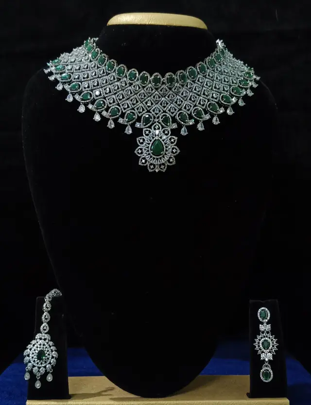 Stone-set bridal choker necklace with matching earrings on a display stand