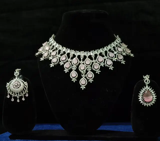 Stone-set bridal choker necklace with matching earrings on a display stand