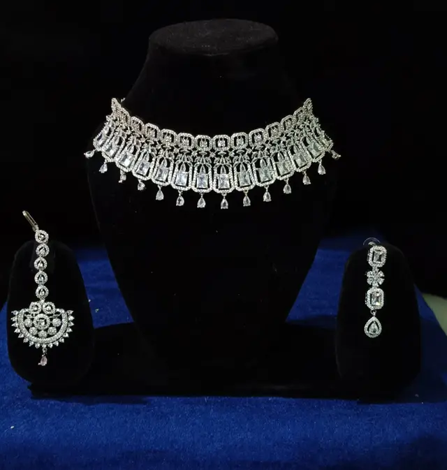 Stone-set bridal choker necklace with matching earrings on a display stand