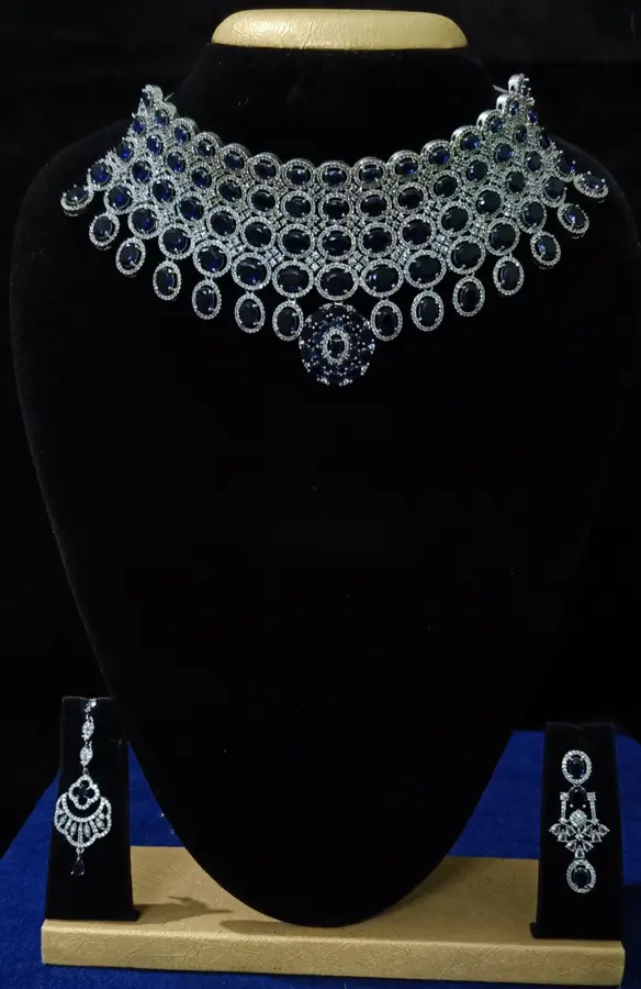 Stone-set bridal choker necklace with matching earrings on a display stand