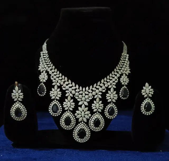 Stone-set bridal choker necklace with matching earrings on a display stand