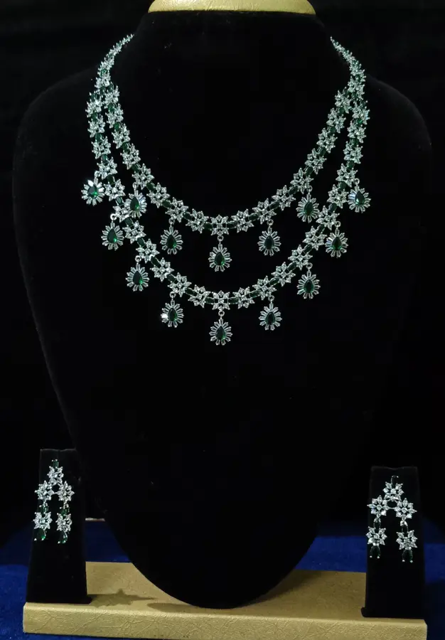 Stone-set bridal choker necklace with matching earrings on a display stand