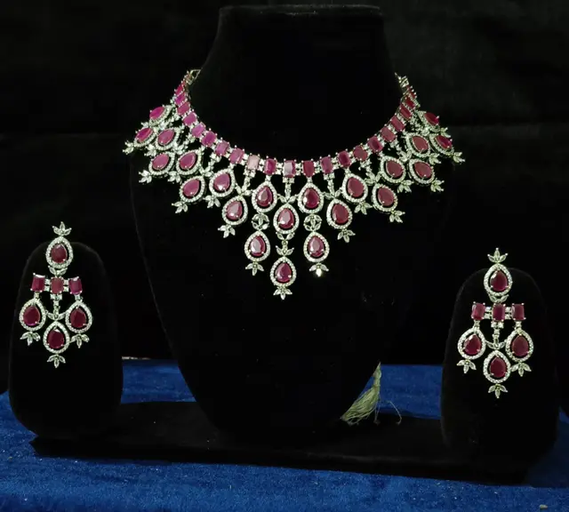 Stone-set bridal choker necklace with matching earrings on a display stand