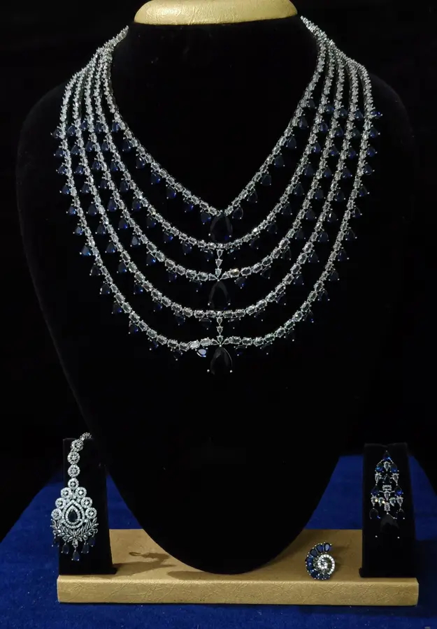 Stone-set bridal choker necklace with matching earrings on a display stand