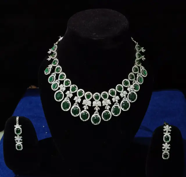 Stone-set bridal choker necklace with matching earrings on a display stand