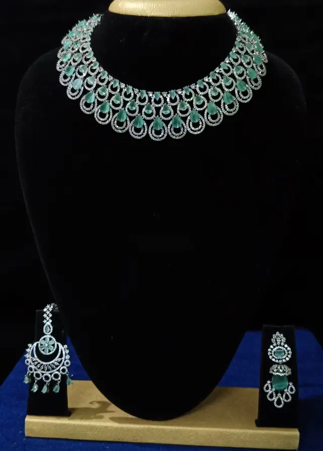 Stone-set bridal choker necklace with matching earrings on a display stand