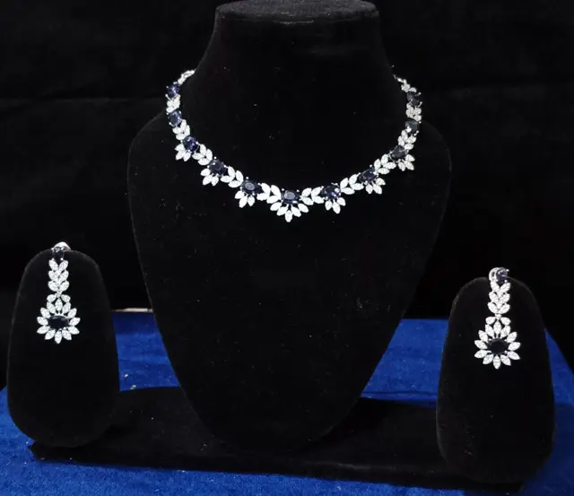 Stone-set bridal choker necklace with matching earrings on a display stand