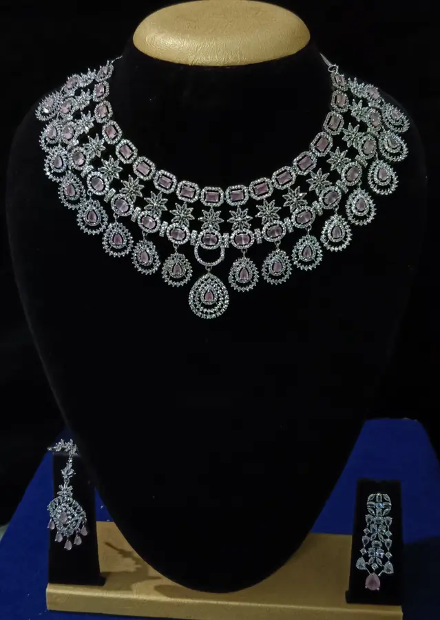 Stone-set bridal choker necklace with matching earrings on a display stand