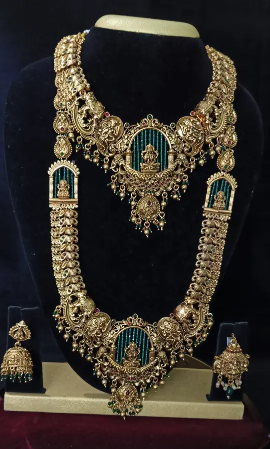 Antique gold-toned temple jewellery bridal set — long haram, short necklace and jhumka on a display stand