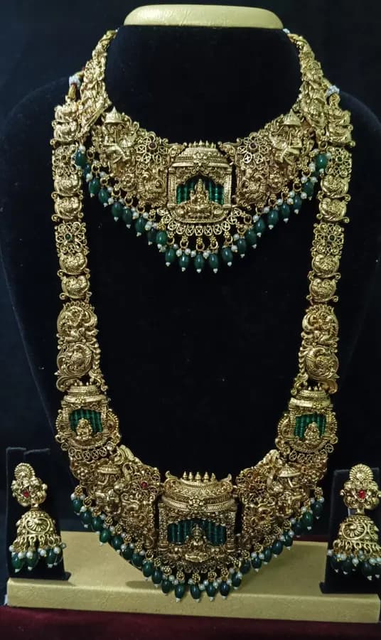 Antique gold-toned temple jewellery bridal set — long haram, short necklace and jhumka on a display stand