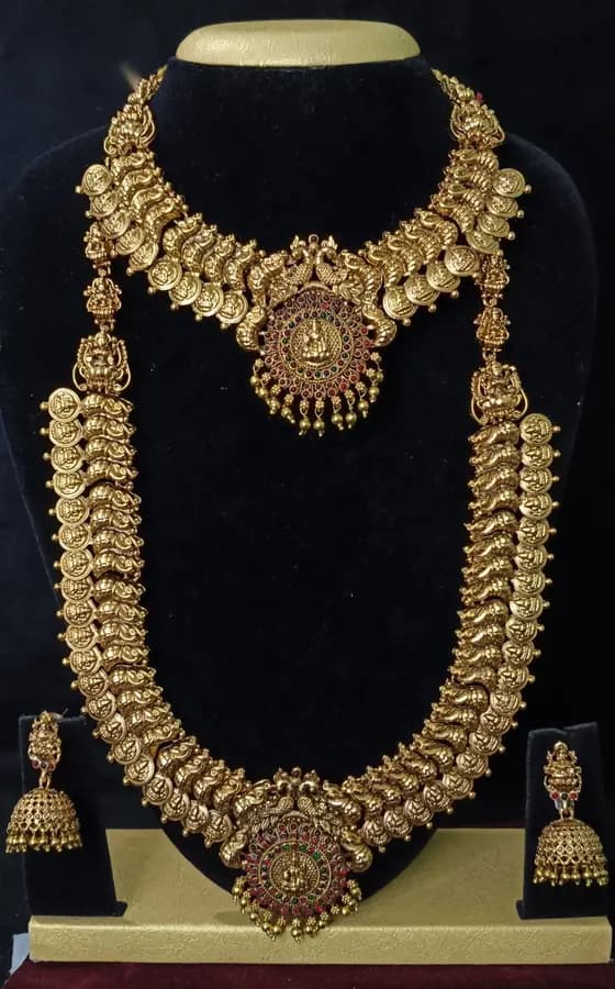 Antique gold-toned temple jewellery bridal set — long haram, short necklace and jhumka on a display stand