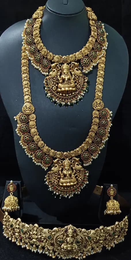 Antique gold-toned temple jewellery bridal set — long haram, short necklace and jhumka on a display stand