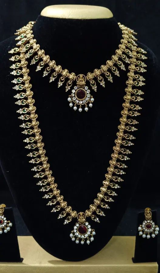 Antique gold-toned temple jewellery bridal set — long haram, short necklace and jhumka on a display stand