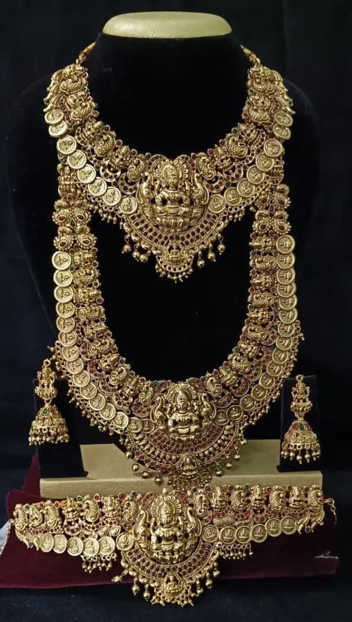 Antique gold-toned temple jewellery bridal set — long haram, short necklace and jhumka on a display stand