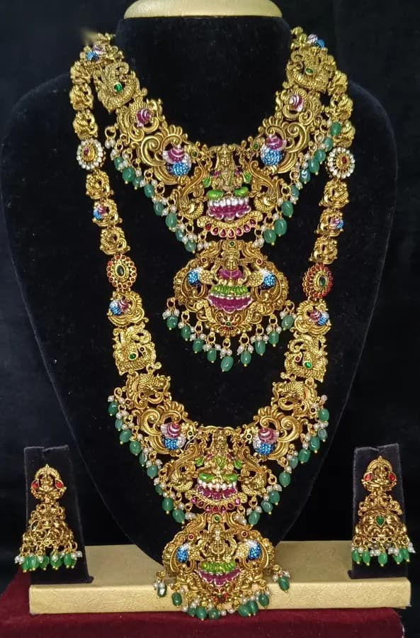Antique gold-toned temple jewellery bridal set — long haram, short necklace and jhumka on a display stand