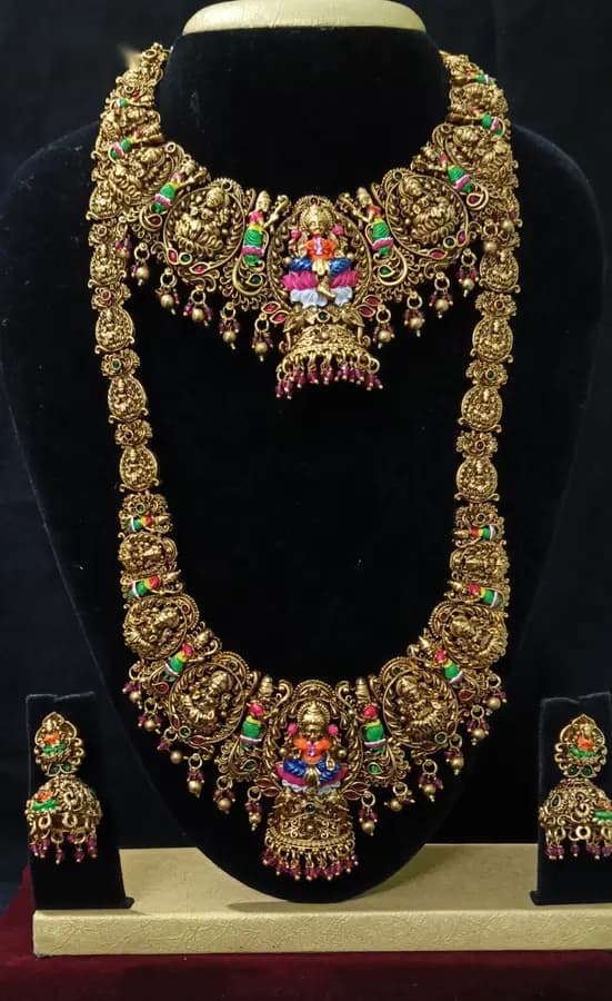 Antique gold-toned temple jewellery bridal set — long haram, short necklace and jhumka on a display stand