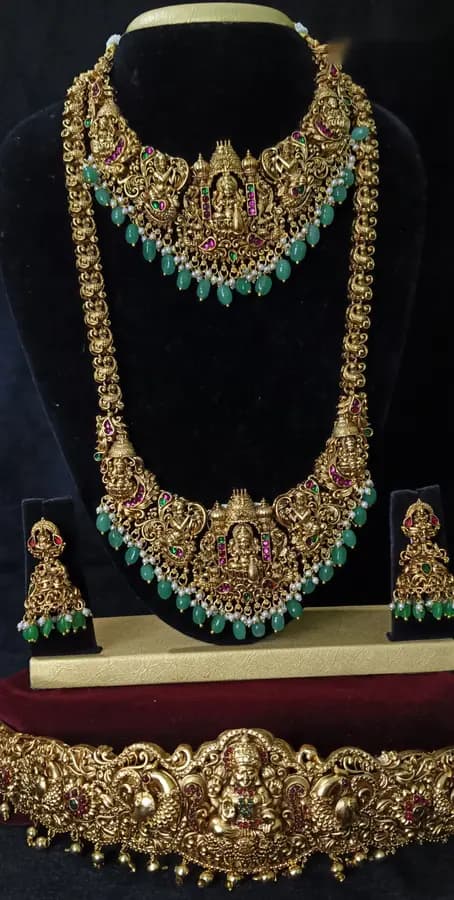 Antique gold-toned temple jewellery bridal set — long haram, short necklace and jhumka on a display stand