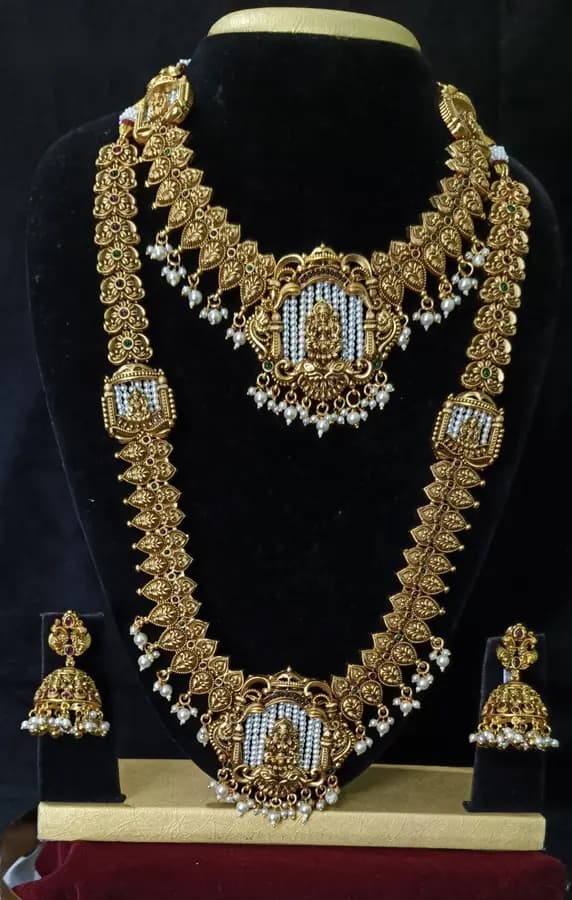 Antique gold-toned temple jewellery bridal set — long haram, short necklace and jhumka on a display stand