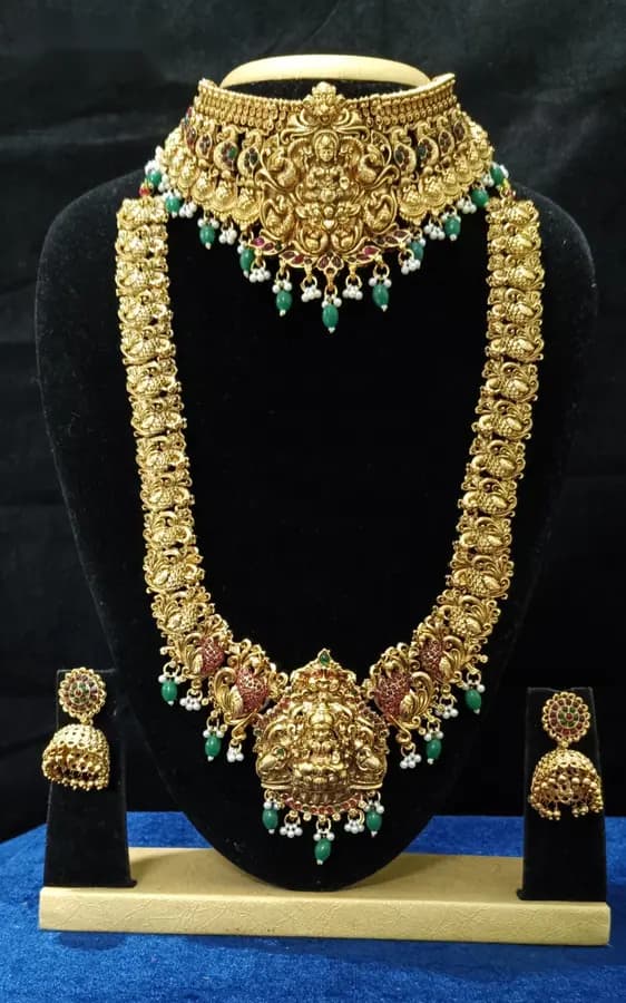 Antique gold-toned temple jewellery bridal set — long haram, short necklace and jhumka on a display stand