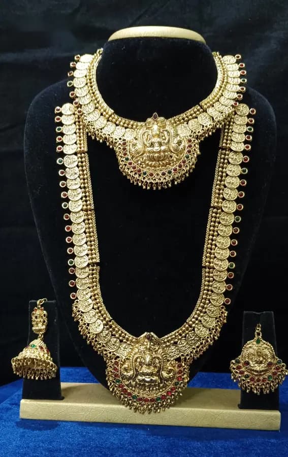 Antique gold-toned temple jewellery bridal set — long haram, short necklace and jhumka on a display stand