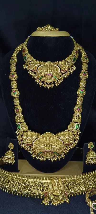Antique gold-toned temple jewellery bridal set — long haram, short necklace and jhumka on a display stand