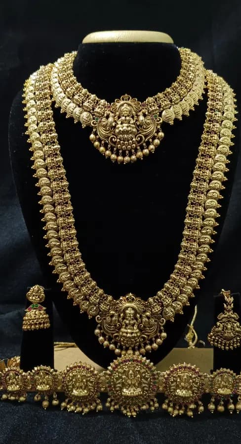 Antique gold-toned temple jewellery bridal set — long haram, short necklace and jhumka on a display stand