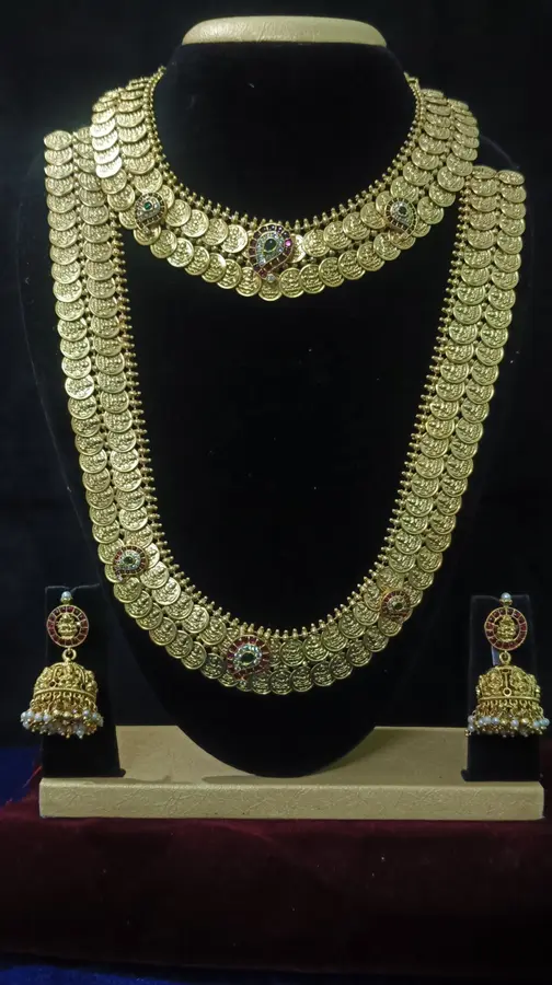 Antique gold temple jewellery bridal set on a display stand — two kasu harams and jhumka